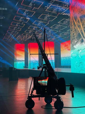 Tampa, Florida, July 2021 — Jimmy Jib crane silhouette against the lit stage screen.