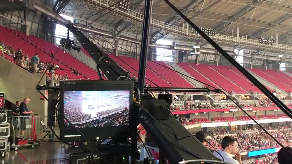 Harvest America, Phoenix, Arizona (2017) — Jib, out of the broader Harvest Crusade ministry. From the Jib platform at field level, over the rig and its monitor, out across the stadium and the crowd in the grandstands.