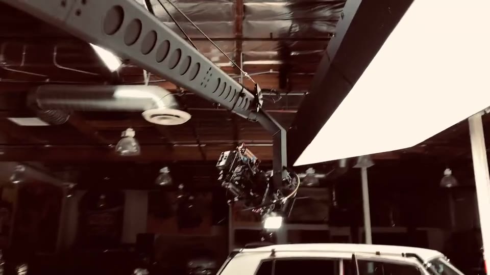 Jay Leno Garage Show (2017) — Jib. Looking straight up from the floor: the ceiling rig, its ducting and the Jib arm entering the frame.